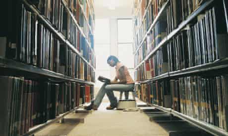 Female University Student Reading a Book in a Library&#13;