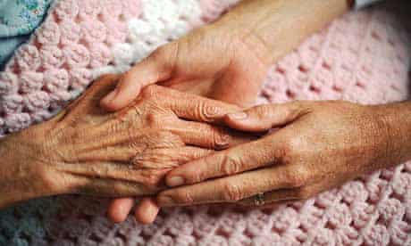  A caring geriatrician holds the hand of an elderly woman with arthritis