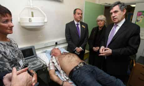 Gordon Brown meets staff at Brocklebank Health Centre, London, as patient John Brennan, 51, is given an ultrasound to check for aneurisms. Photograph: Lewis Whyld