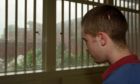 Young offender in a YoI gazes out of the barred window. Image shot 2006.