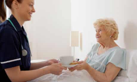 Nurse giving elderly patient tea