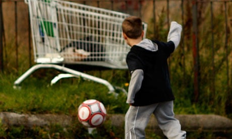Child playing football in rundown area