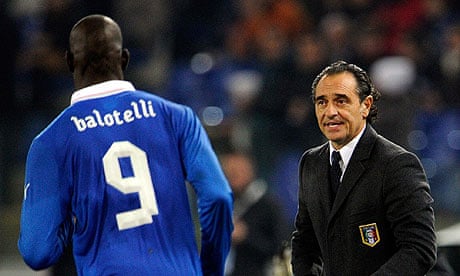 Italy's Cesare Prandelli speaks to Mario Balotelli in the match against Uruguay