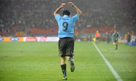 Uruguay's Luis Suárez celebrates after scoring his second during a rain-lashed 2-1 victory