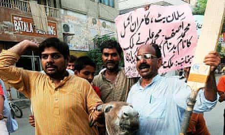 Pakistani cricket fans restrain a donkey