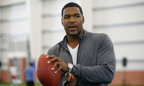 Michael Strahan posing with a ball