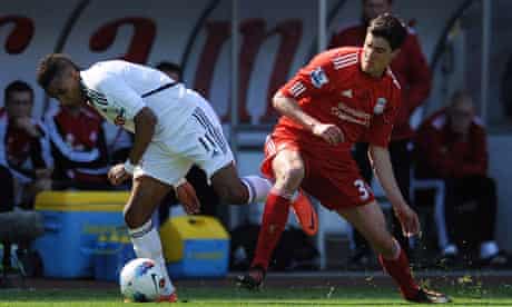 Liverpool's Martin Kelly competes for the ball with Swansea's Scott Sinclair