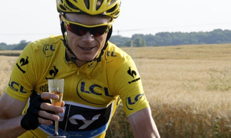 Chris Froome rides with a glass of champagne