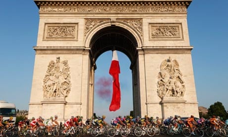 The pack of riders cycles past the Arc de Triomphe