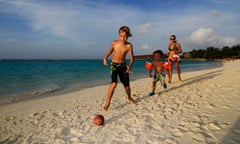 Children playing football on the beach