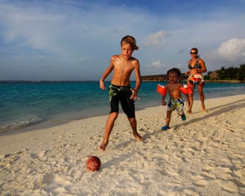 Children playing football on the beach