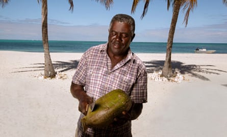North Beach owner Reuben James prepares a coconut 