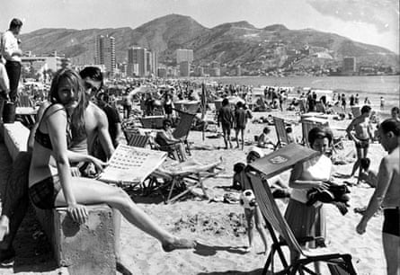 1960's, Benidorm, Spain, A general view of a continental beach scene, with many people sunbathing