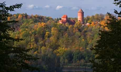 Turaida Castle in Sigulda over autumn forest in Gauja river valley