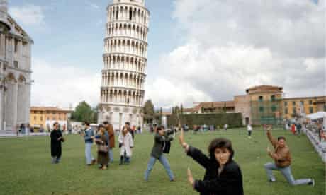 Tourists strike a pose in front of the Leaning Tower of Pisa