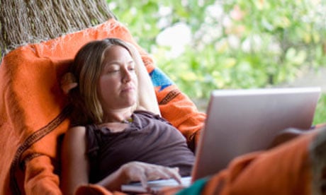 Woman using laptop in a hammock