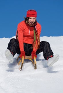 Young woman riding sledge