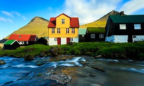Stream running alongside traditionally built houses in the Faroe Islands