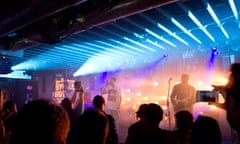 A band plays unders neon lights at Austin's SXSW music festival