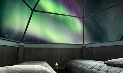 The northern lights through the roof of a glass igloo