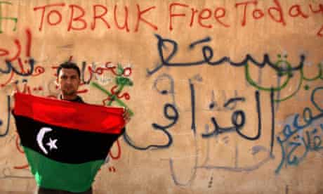 A Libyan anti-government protester holds a flag in Tobruk