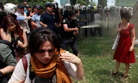 A Turkish policeman uses tear gas on a woman protesting in Gezi Park, Istanbul