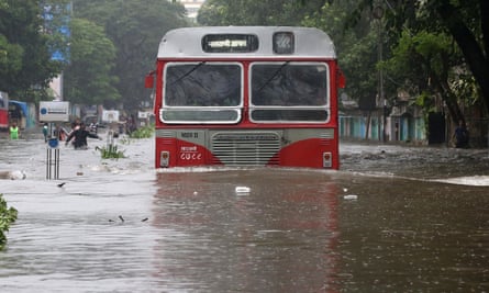 A passenger bus moves through a waterlogged road in Mumbai.