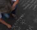 Activist writes the names of political prisoners still incarcerated in a vigil outside El Helicoide