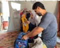 Alaa looks through the clothing that belonged to her three children, who were killed in an Israeli strike