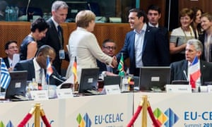 Greek Prime Minister Alexis Tsipras, center right, shakes hands with German Chancellor Angela Merkel, center left, at the start of a round table meeting at the EU-CELAC summit in Brussels on Wednesday, June 10, 2015. Greece’s prime minister was hoping to meet with the leaders of Germany and France in Brussels Wednesday, in the latest effort to break a bailout negotiation deadlock that has revived fears his country could default and drop out of the euro. (AP Photo/Geert Vanden Wijngaert)