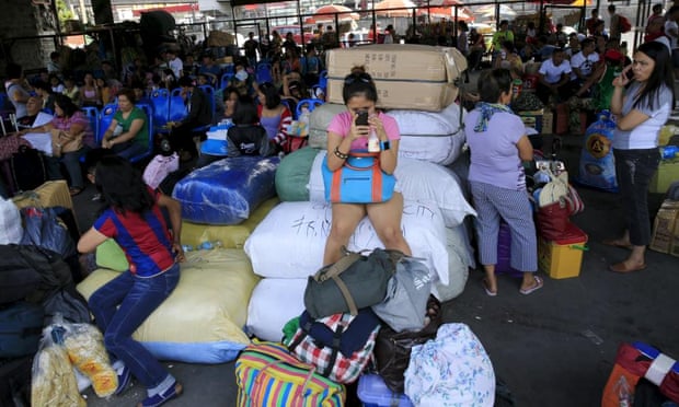 Stranded passengers guard their belongings while waiting at a bus terminal in Manila