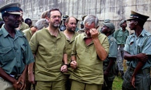 Simon Mann, left, the leader of a group of foreign mercenaries, leaves court in Harare in March 2003