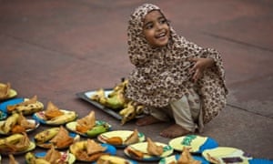 A girl arranges plates before iftar 