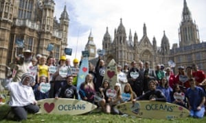 Climate change campaigners pose in front of the Houses of Parliament in London on June 17, 2015, ahead of mass lobby to urge members of parliament to back strong action on climate change.