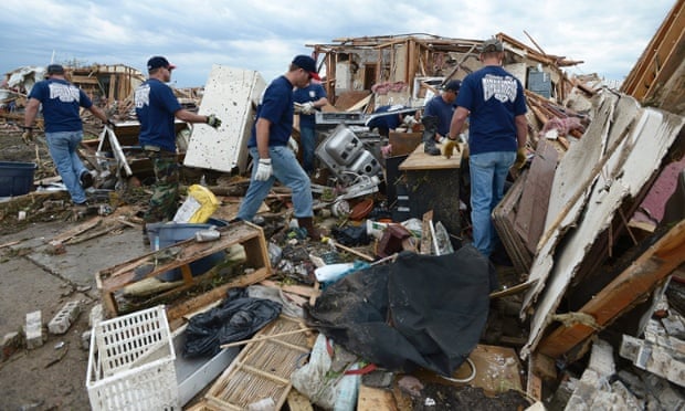 Firefighters help a fellow firefighter recover belongings from the ...