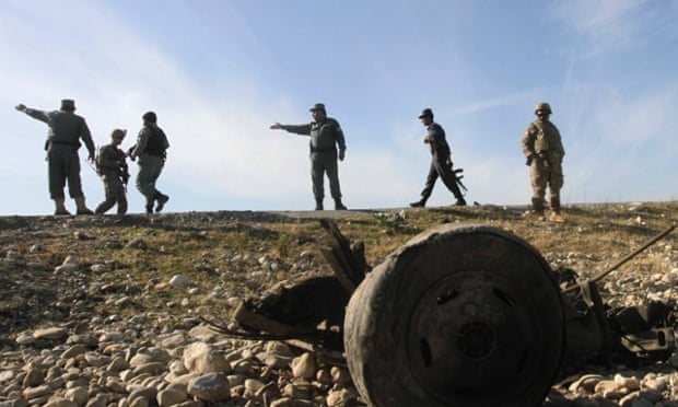 US troops and Afghan police officers at the site of a suicide attack on the outskirts of Jalalabad on 13 November 2014.