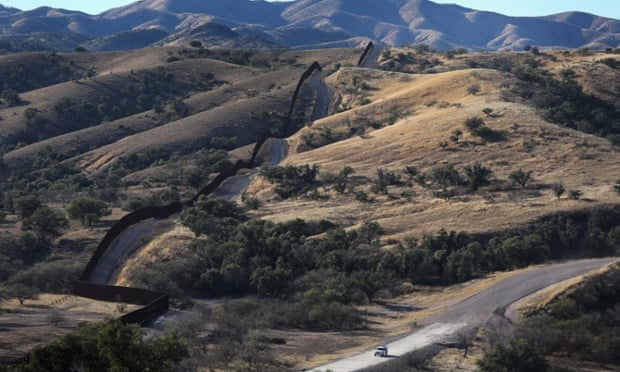 US border patrol vehicle drives along the U.S.-Mexico border fence on 9 December 2014 near Nogales, Arizona.