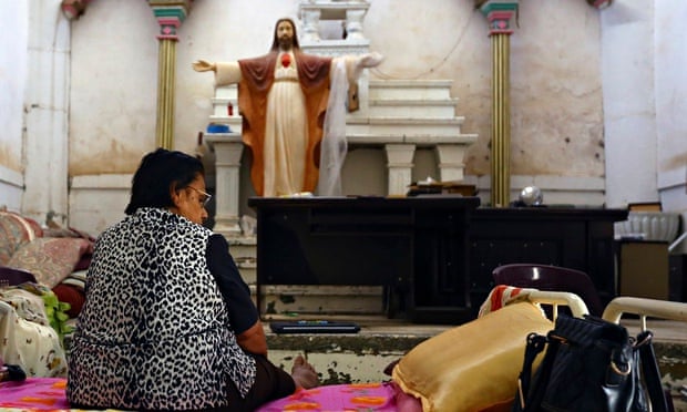 An Iraqi Christian woman sits inside a church in Telkaif near Mosul