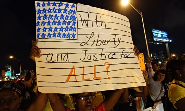 A woman holds a placard in Miami during a protest against police killings