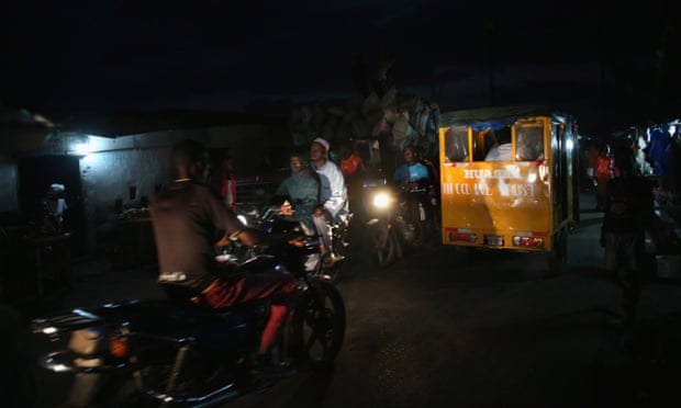 People drive through the dark in the favella of West Point, where few homes have electricity in Monrovia, Liberia.