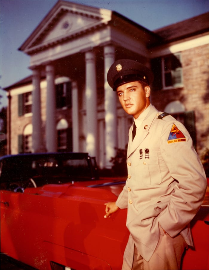 Elvis in army uniform outside Graceland