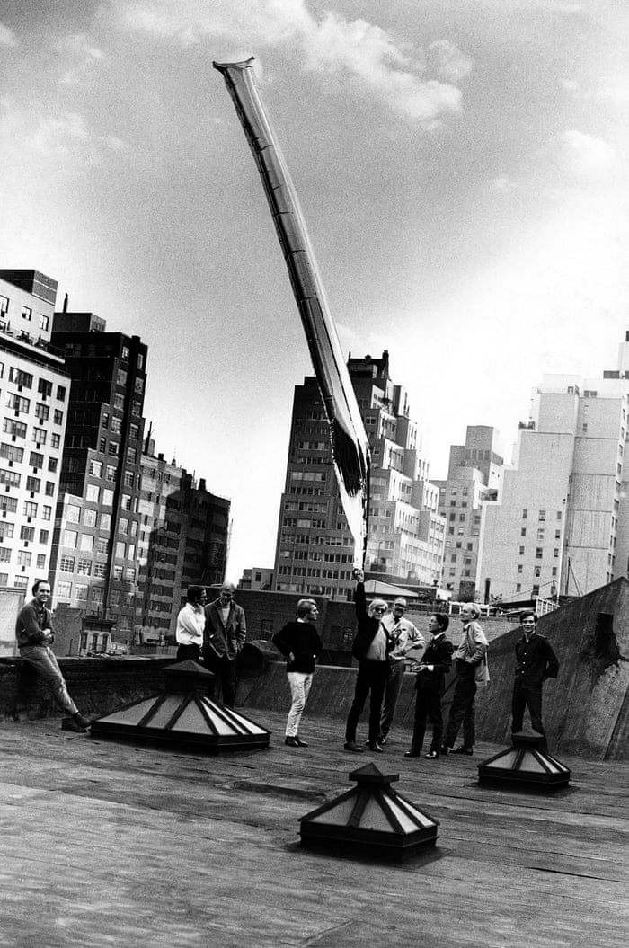Andy Warhol with silver balloon sculpture, the factory 'Andy, Gerard Malanga and onlookers release the silver ‘cloud’ from the Factory rooftop on 47th Street. Factory regulars would occasionally sneak up there to smoke cannabis but on this day Andy released a floating work of art to the sky.'