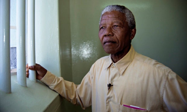 Nelson Mandela stands at the window of the cell in Robben Island prison where he was incarcerated fo