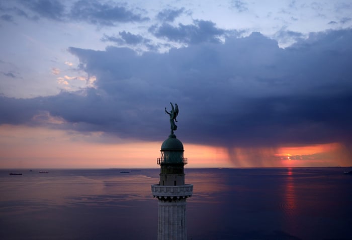 Trieste, Italy: The Vittoria Light, overlooking the Gulf of Trieste at sunset as a storm approaches.