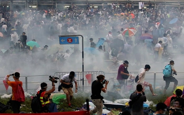 People disperse after police fired tear gas upon pro-democracy demonstrators near the Hong Kong government headquarters.