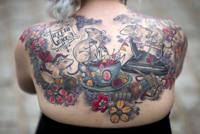 A woman displays her back tattoo at the London Tattoo Convention in London.